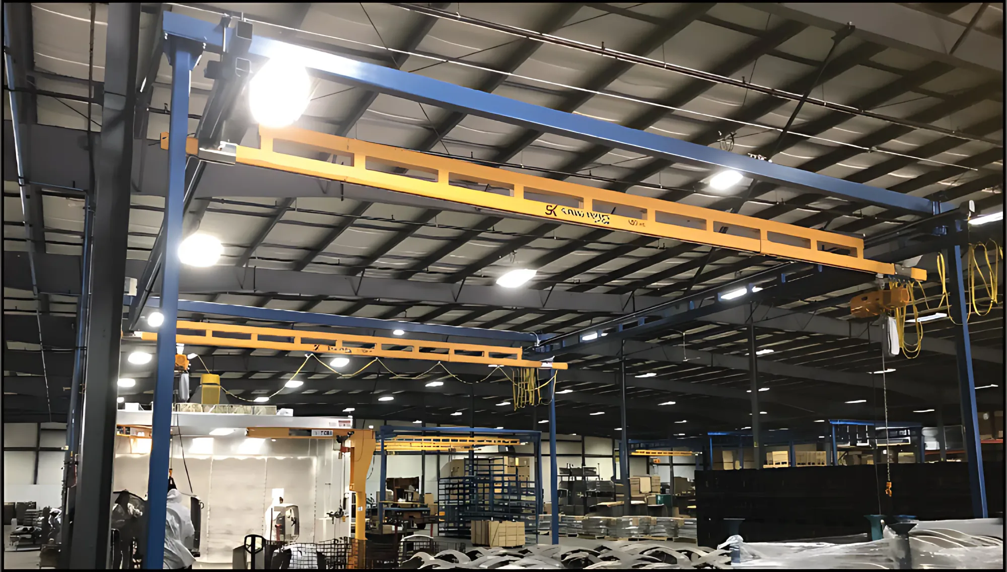 Estaciones de trabajo modulares amarillas sobre estructuras azules en una planta industrial