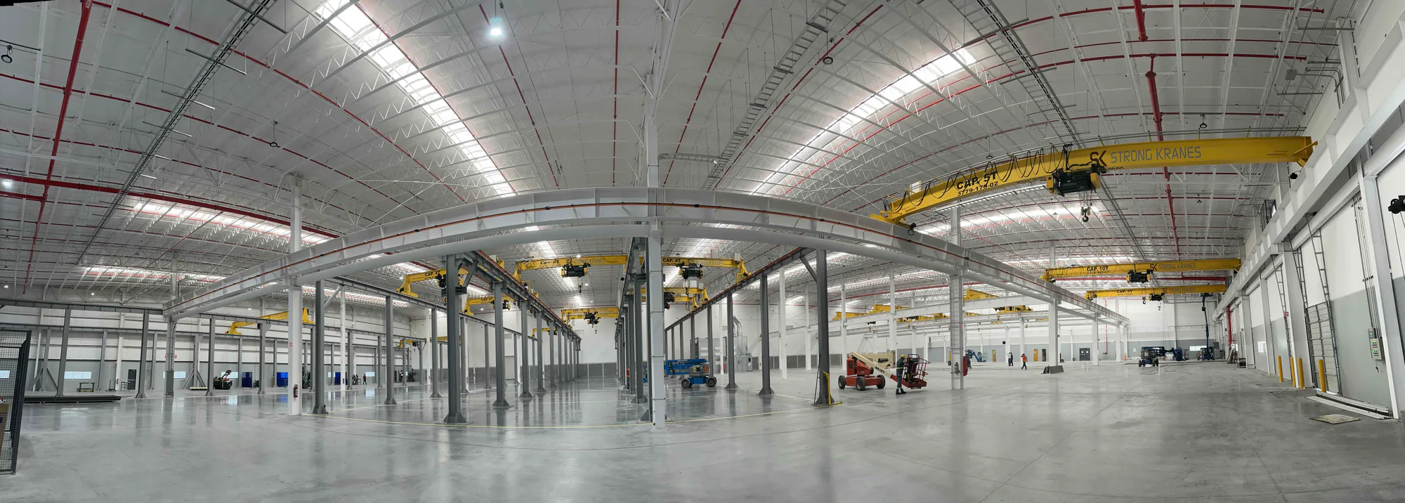 Vista panorámica de estaciones de trabajo y grúas ligeras instaladas en una planta industrial