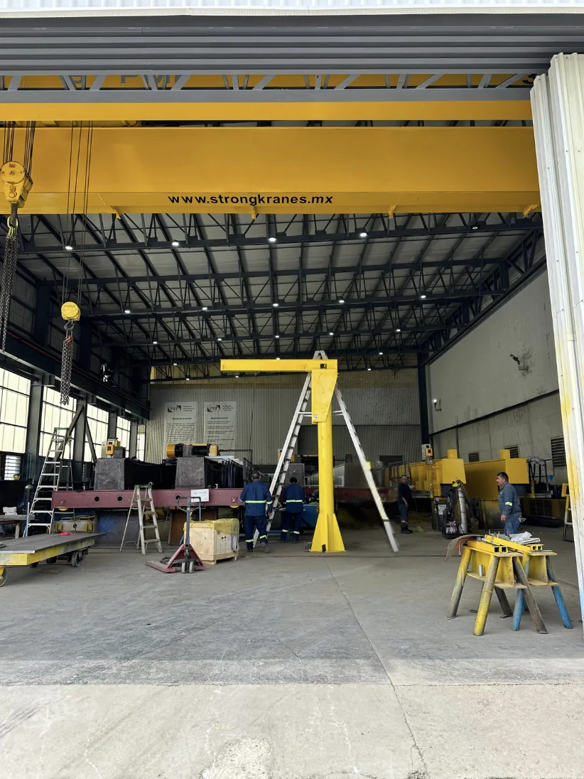 Yellow jib crane during fabrication in the Strong Kranes workshop