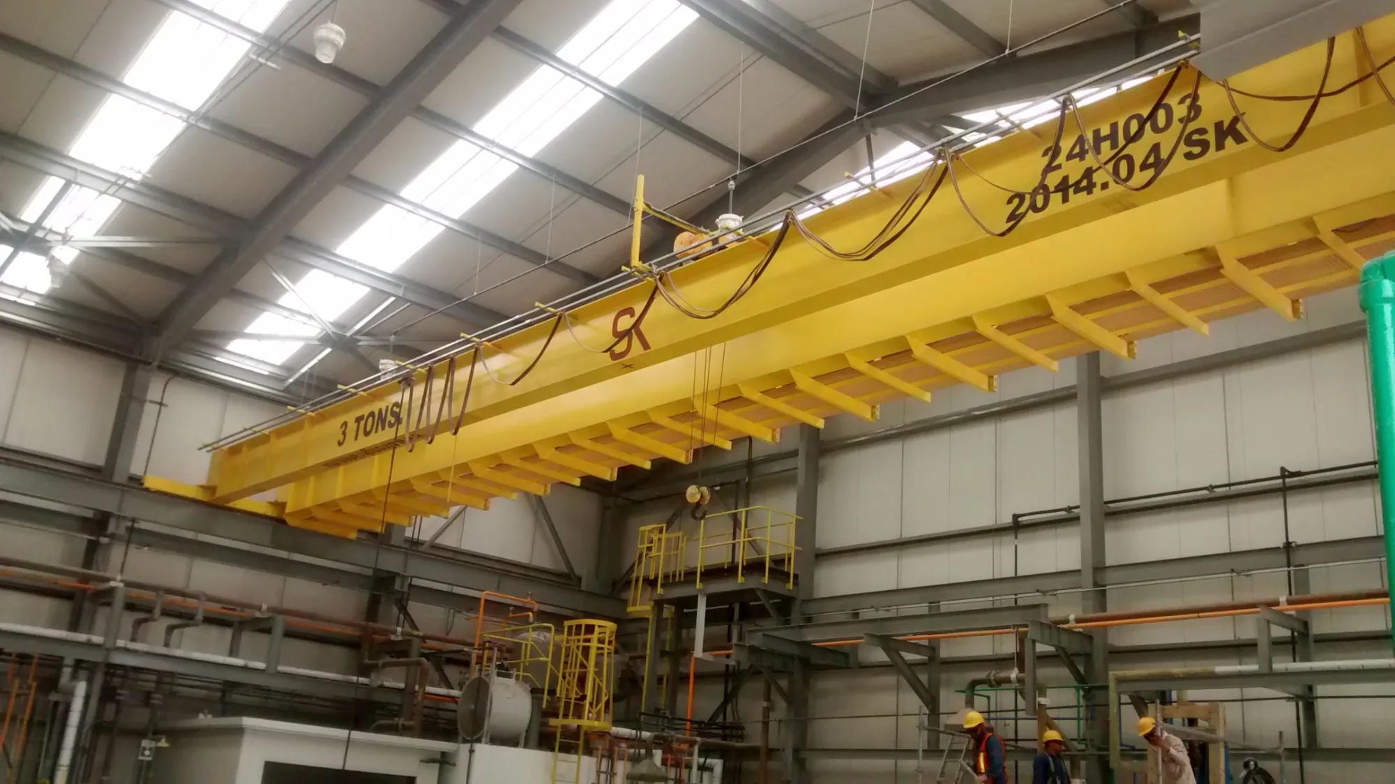 Grúa viajera bipuente amarilla de 3 toneladas instalada en una nave industrial