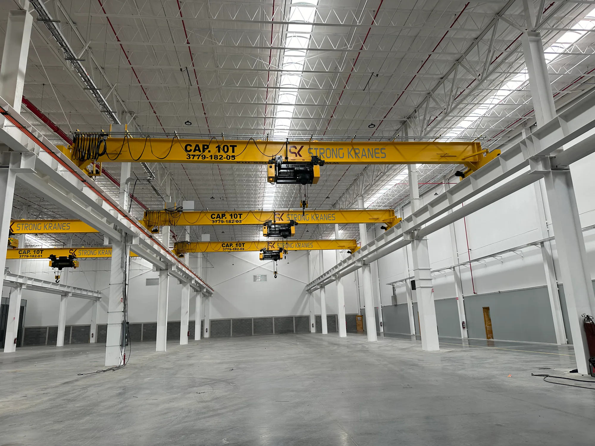 Sistema de tres grúas viajeras monopuente de 10 toneladas instalado en una nave industrial